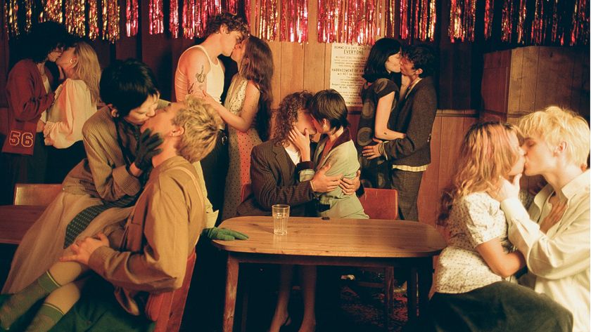 A lively gathering with multiple couples engaged in intimate moments, set against a backdrop of colorful streamers and a cozy atmosphere