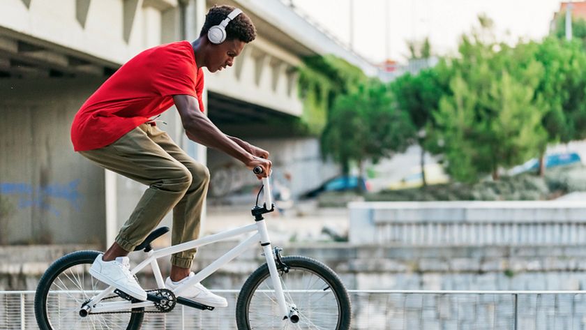 A person wearing over-ear headphones on a bike