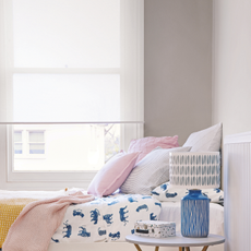 A small bedroom with an opaque roller blind over the window