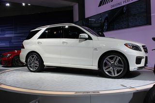 White Mercedes-Benz ML63 AMG, on a grey circular display stand, showroom backdrop