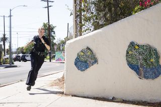 Maddie (Madison Lintz) runs around the corner of a Los Angeles street in police uniform, chasing an unseen suspect
