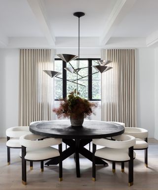 dining room with black round table and white chairs