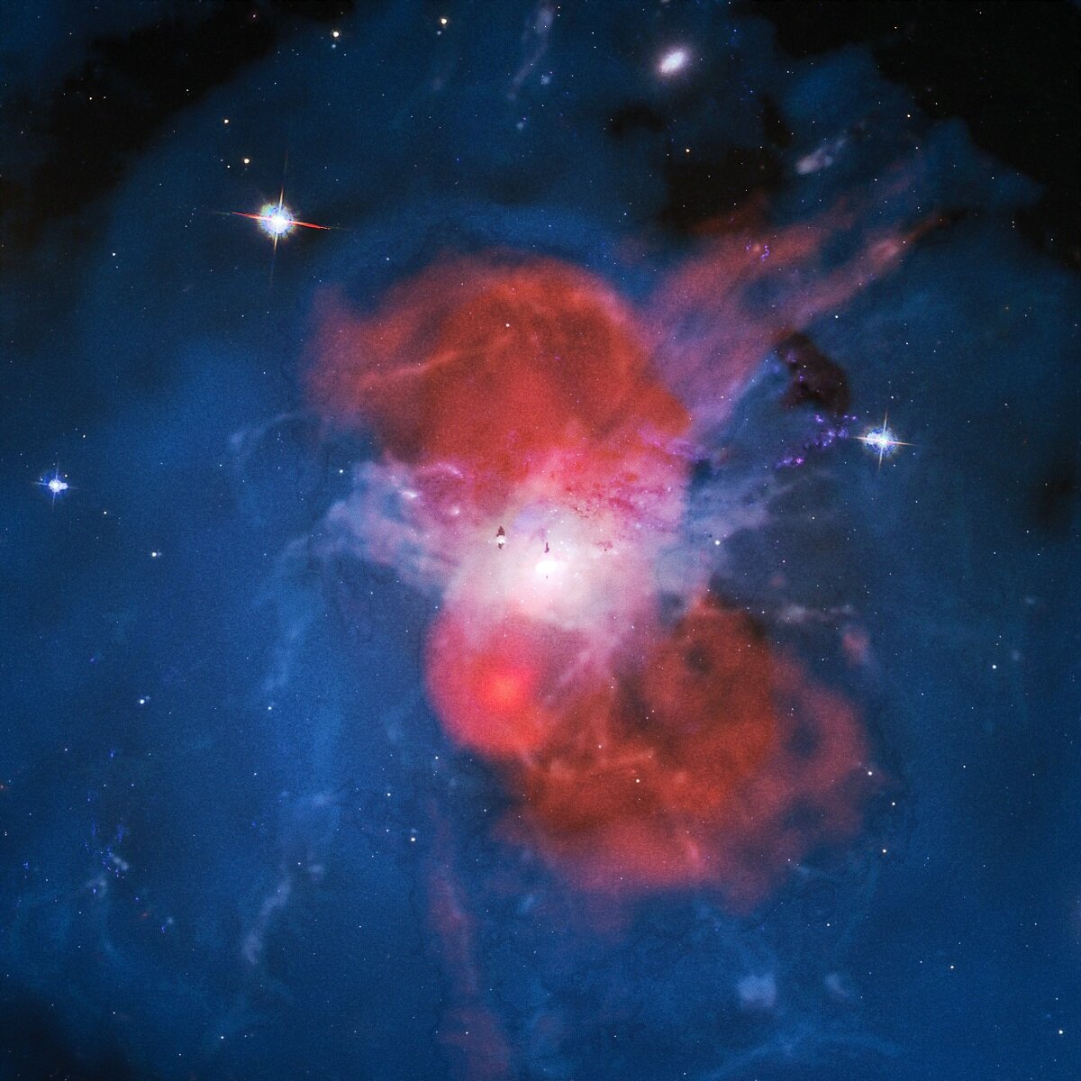 Samengesteld beeld van het centrum van de cluster van sterrenstelsels van Perseus.  Rood is de radio-uitzending die LOFAR ontvangt.  Blauw zijn röntgenfoto's gemaakt door de Chandra-telescoop.  Wit is waterstof van de H-alpha-kaart van de WIYN-telescoop.  De achtergrond is de nachtelijke hemel in optisch licht van de Hubble-telescoop.