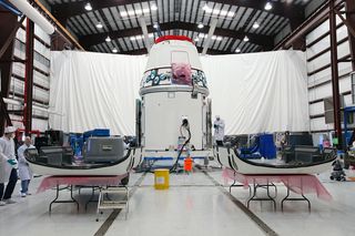 Workers prepare solar array fairings at the processing hangar used by Space Exploration Technologies, or SpaceX, at Cape Canaveral Air Force Station, Fla. This image was released Jan. 12, 2013.