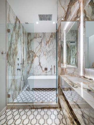A marble tiled bathroom with freestanding bath