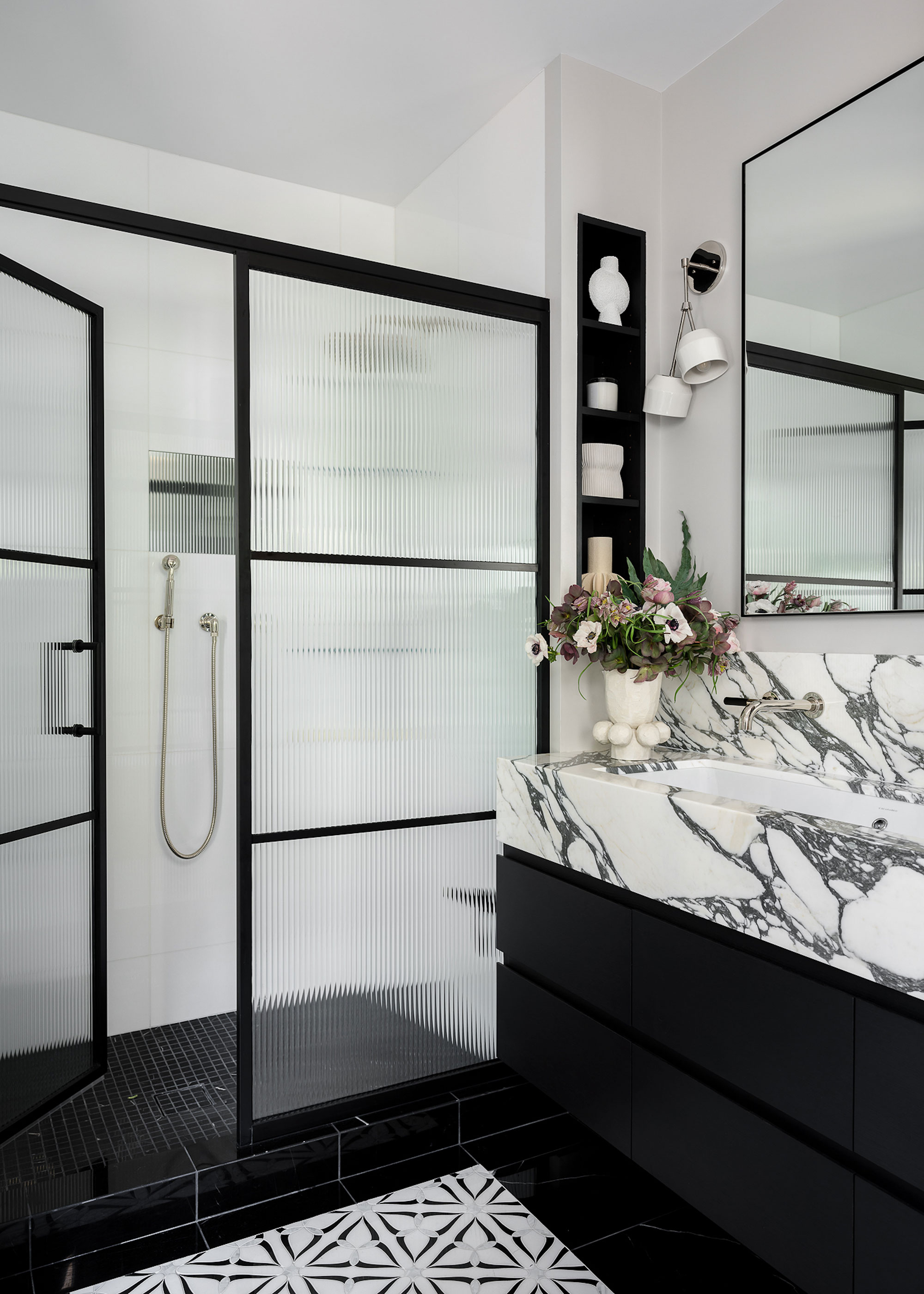 black and marble bathroom with walk in shower with fluted glass shower screen