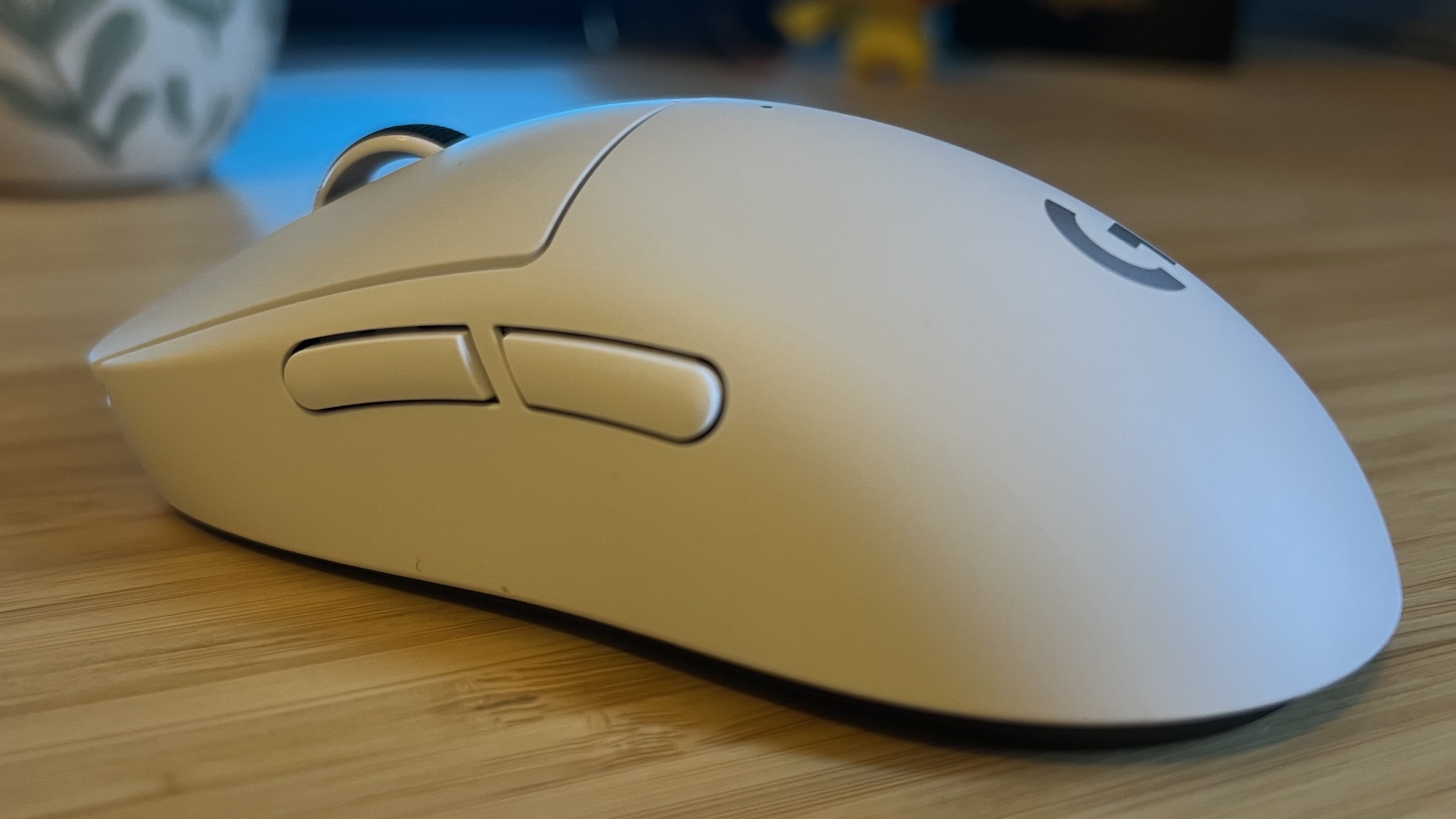 Left side of Logitech G Pro X Superlight 2c gaming mouse on a wooden desk