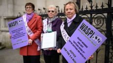 A group of women representing the WASPI protest group stand outside the Royal Courts of Justice during a demonstration