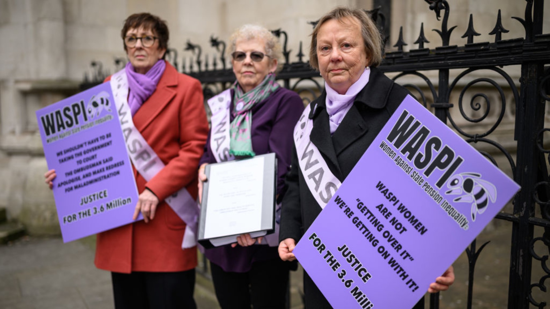 A group of women representing the WASPI protest group stand outside the Royal Courts of Justice during a demonstration
