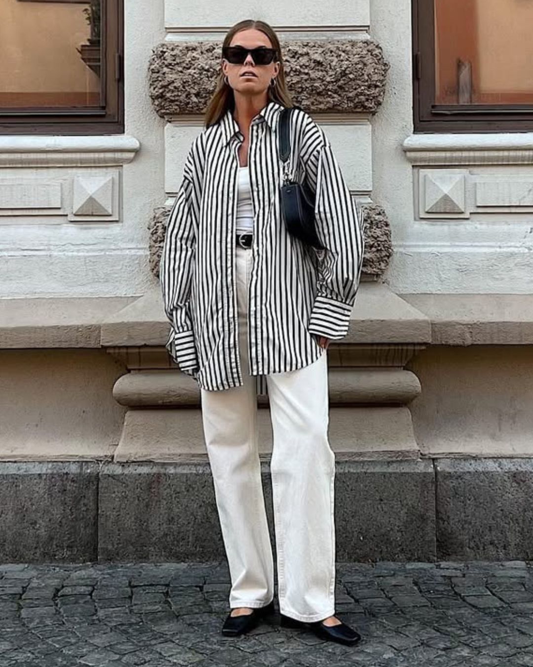 @haaannajohansson wears an Oxford shirt, white jeans, black ballet flats and a shoulder bag