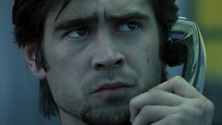 Colin Farrell looking out of the booth suspiciously while on the phone in Phone Booth.