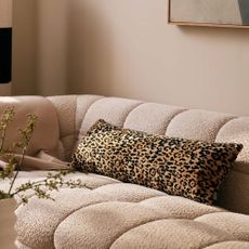 Leopard print bolster cushion on a boucle sofa