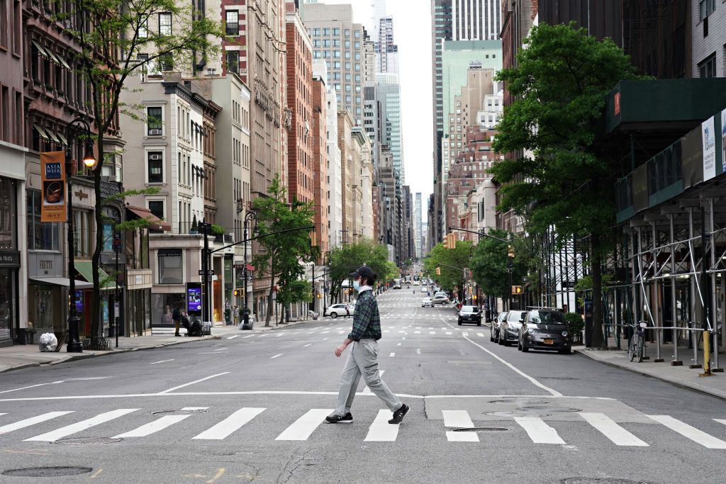 A masked person walks in New York City.