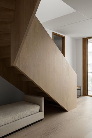 Modern residential interior with an architectural wooden staircase.