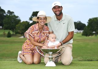 Scottie Scheffler with his wife, Meredith, and their son Bennett and the FedExCup Trophy after winning the Tour Championship in 2024