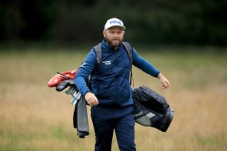 Sullivan walks with his golf bag on his back