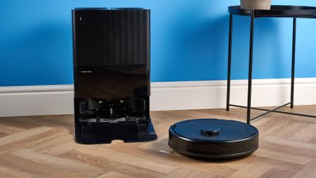 Roborock QV 35S with dock photographed in front of a blue background