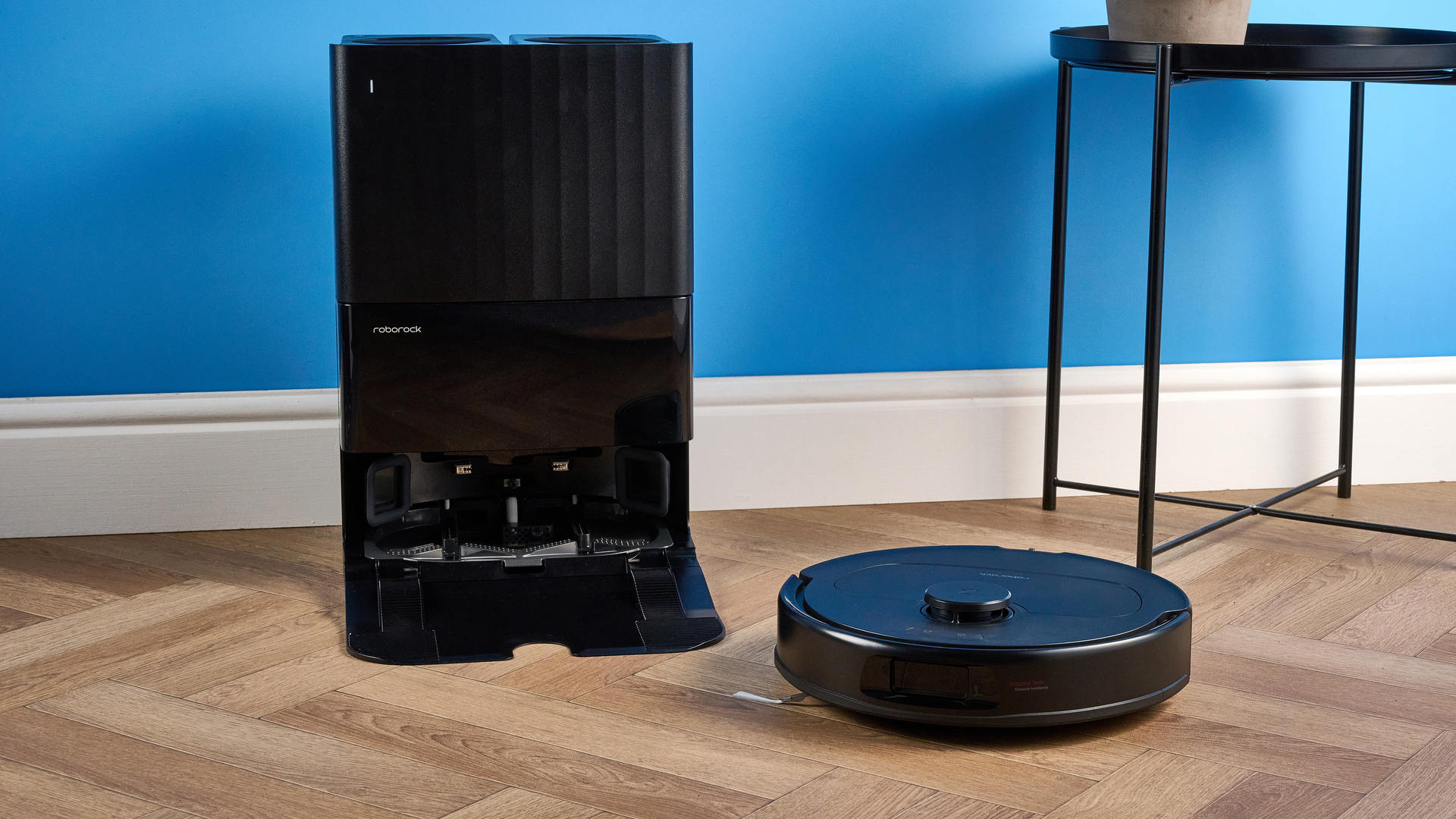 Roborock QV 35S with dock photographed in front of a blue background