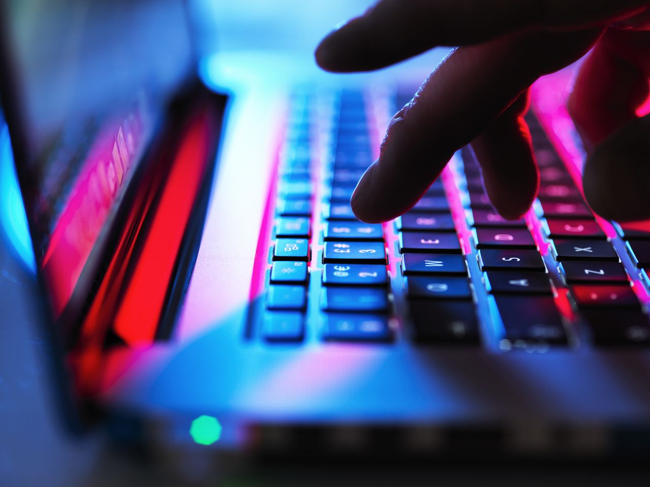 Man typing at his laptop computer