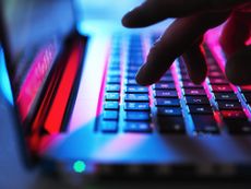 Man typing at his laptop computer