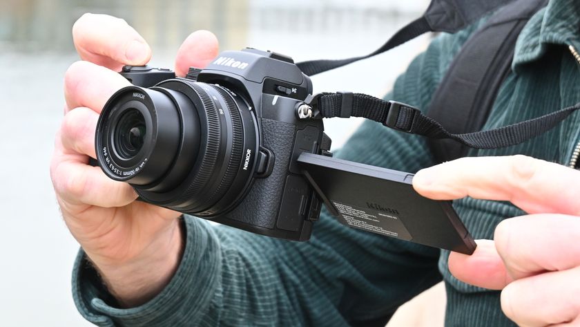 Man holding Nikon Z50 II with rear screen tilted