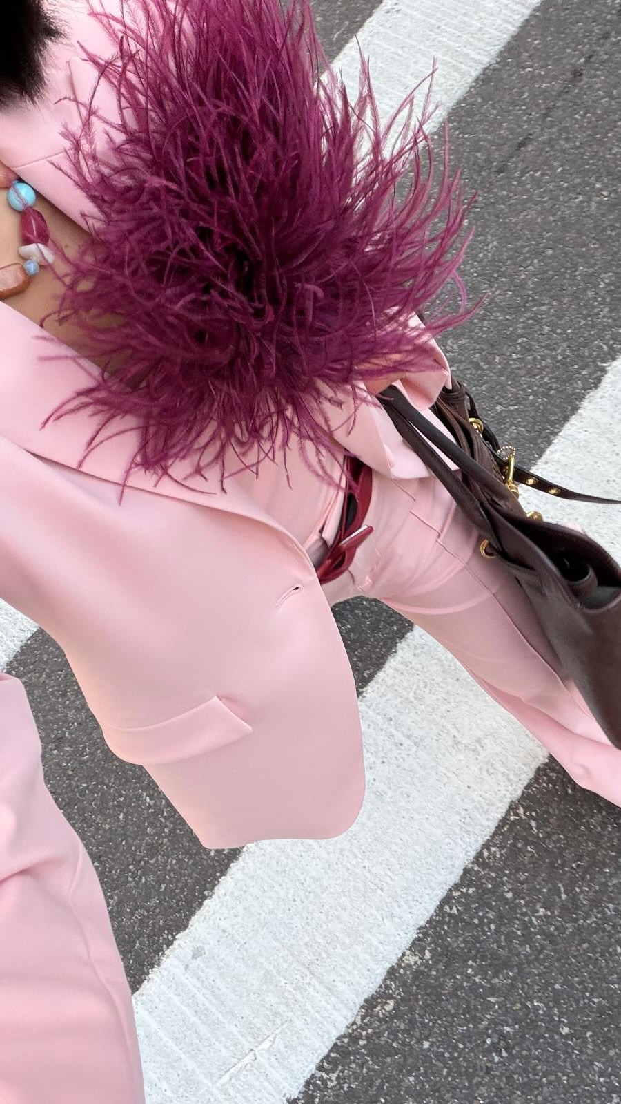 Influencer @aprillockhart wears a pink suit with a purple feathery brooch.