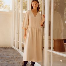 A woman in a cream coloured dress from Everlane