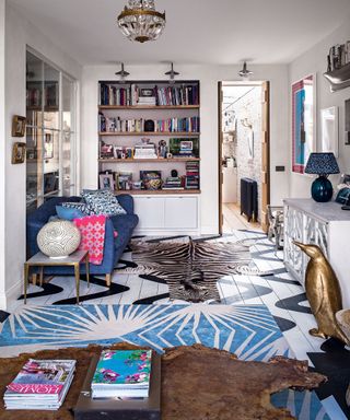 Clashing color boho living room ideas illustrated by a combination of blue, brown and zebra print rugs and colorful accessories in a white scheme.