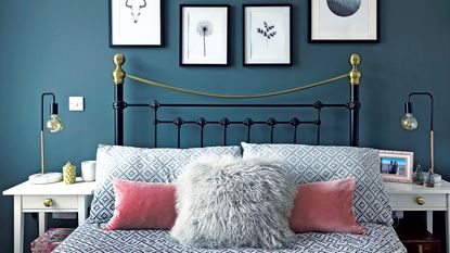 a green bedroom with green painted walls and a bed with pink bedn linen with two baskets on the floor at the end of the bed