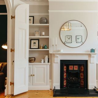 White wall with floating shelves next to fireplace