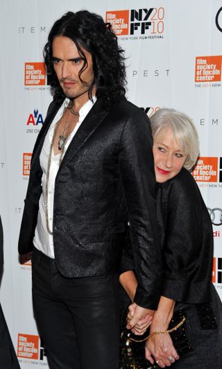 Helen Mirren hites behind her Tempest co-star Russell Brand on the red carpet