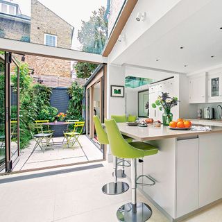 kitchen with white walls and green chairs