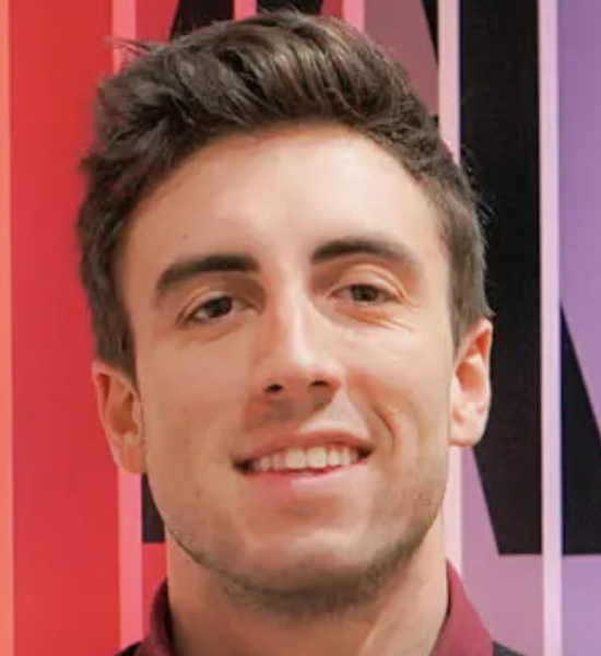 a white man with brown hair smiling at the camera