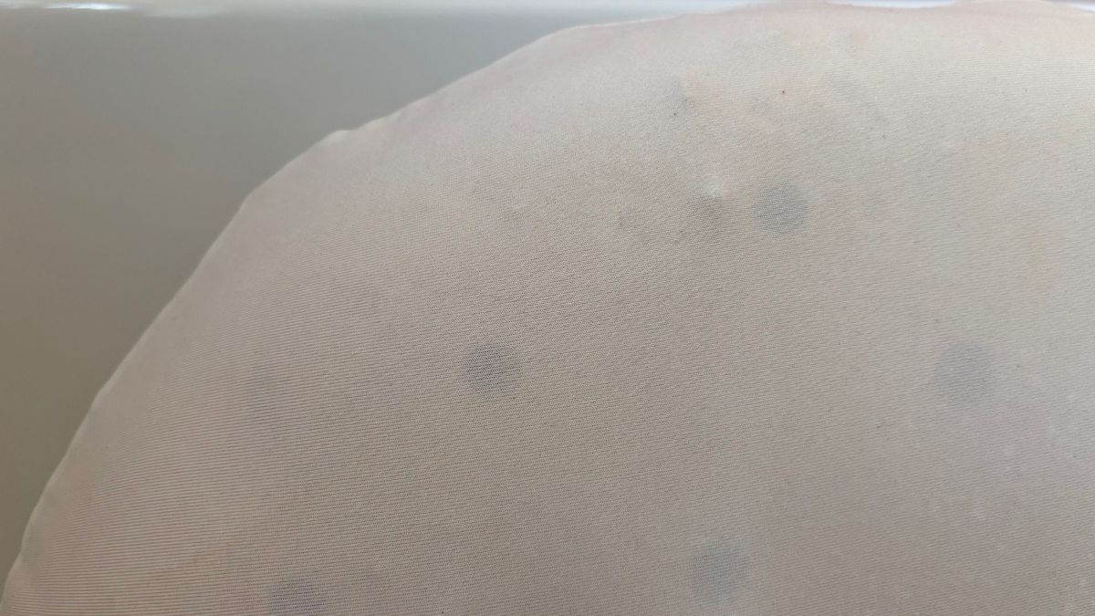 The image shows the corner of a white pillow, after yellow set-in stains have been removed