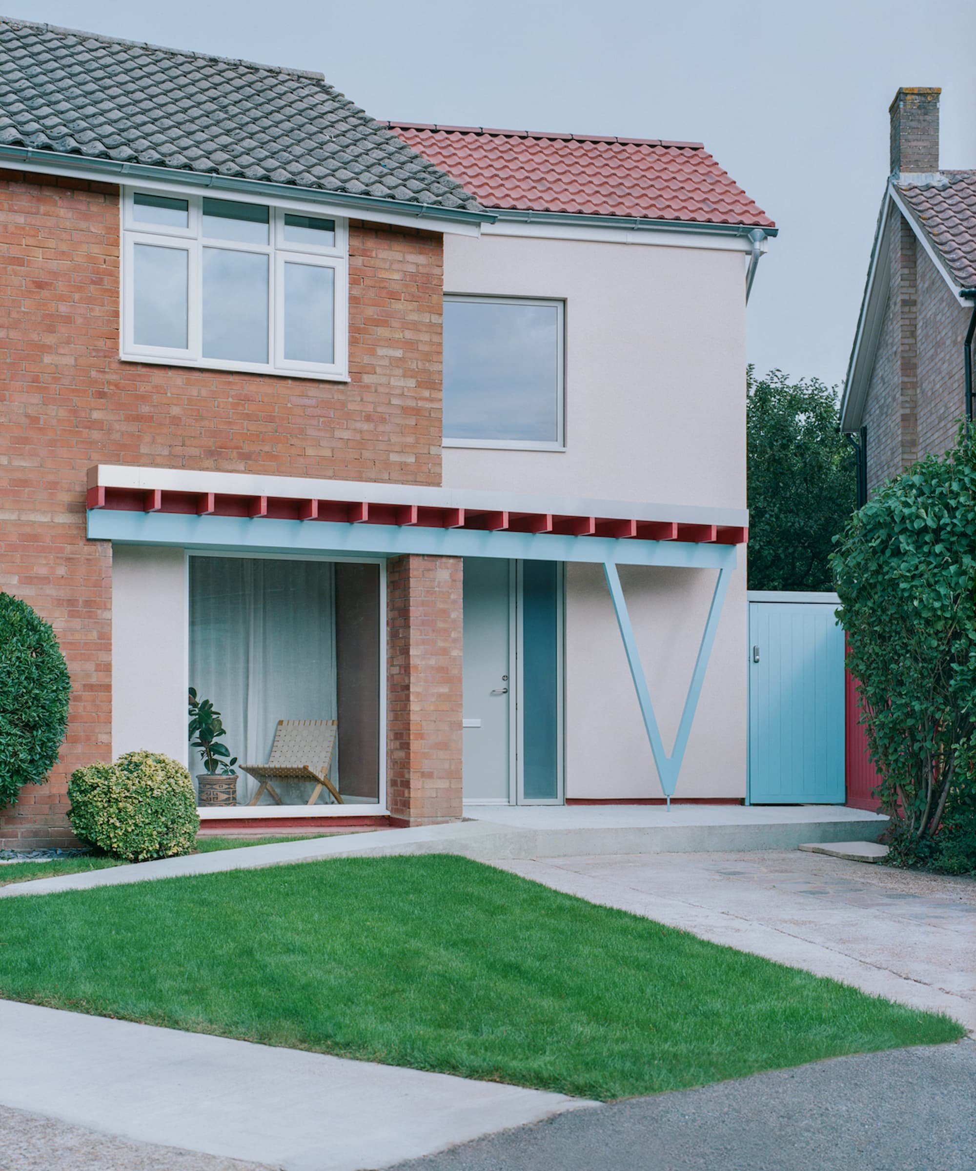 A V shaped canopy in blue at the front of a white house