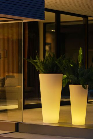 porch decor ideas with planters that are also lamps glowing in the dusk