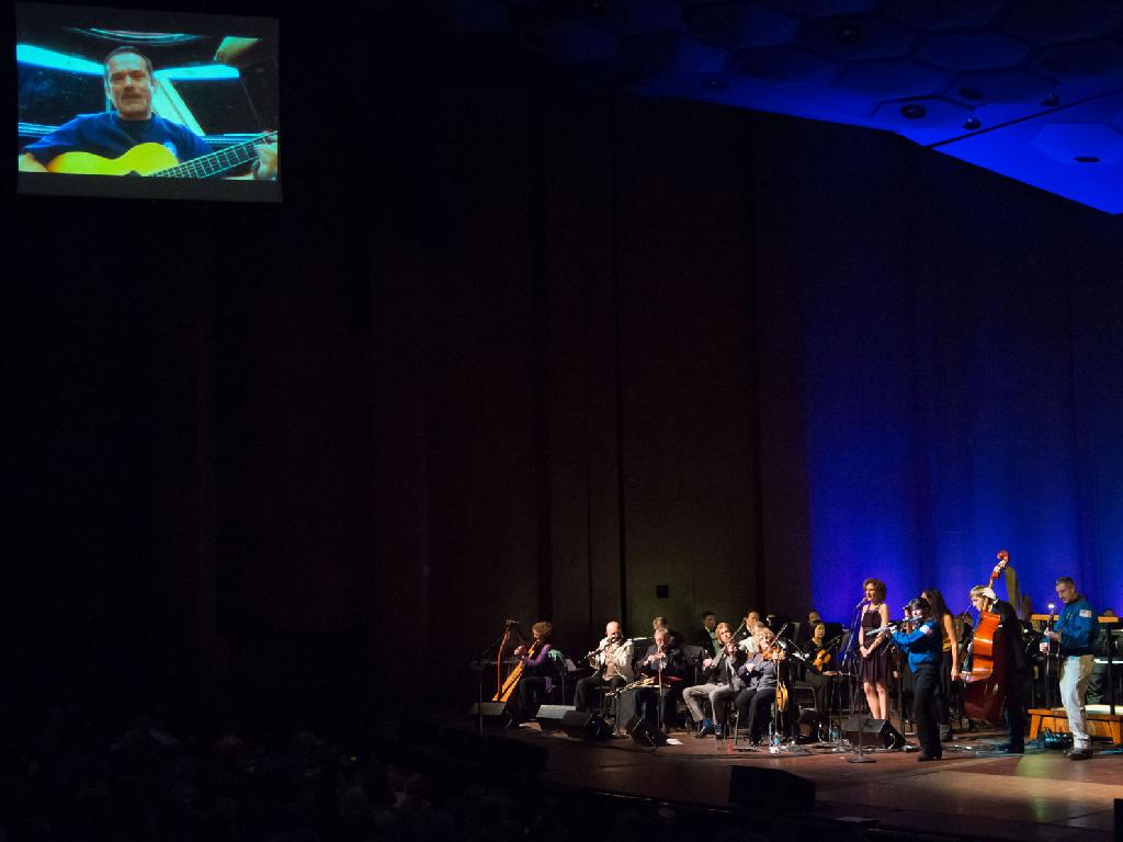 Canadian astronaut Chris Hadfield (top left) and NASA astronauts Cady Coleman and Dan Burbank (in blue flight jackets) perform with the traditional Irish band The Chieftains on Feb. 15, 2013, at Jones Hall in Houston during the bands 50th anniversary tour. Hadfield prerecorded his portion on the International Space Station.