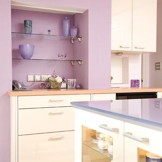 purple walled kitchen with worktop and white drawers