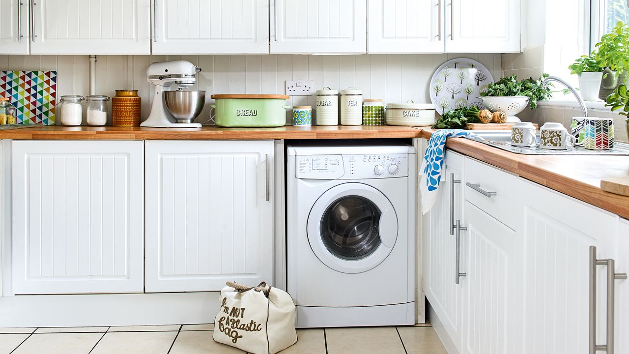 White kitchen with washing machine, sink and KitchenAid