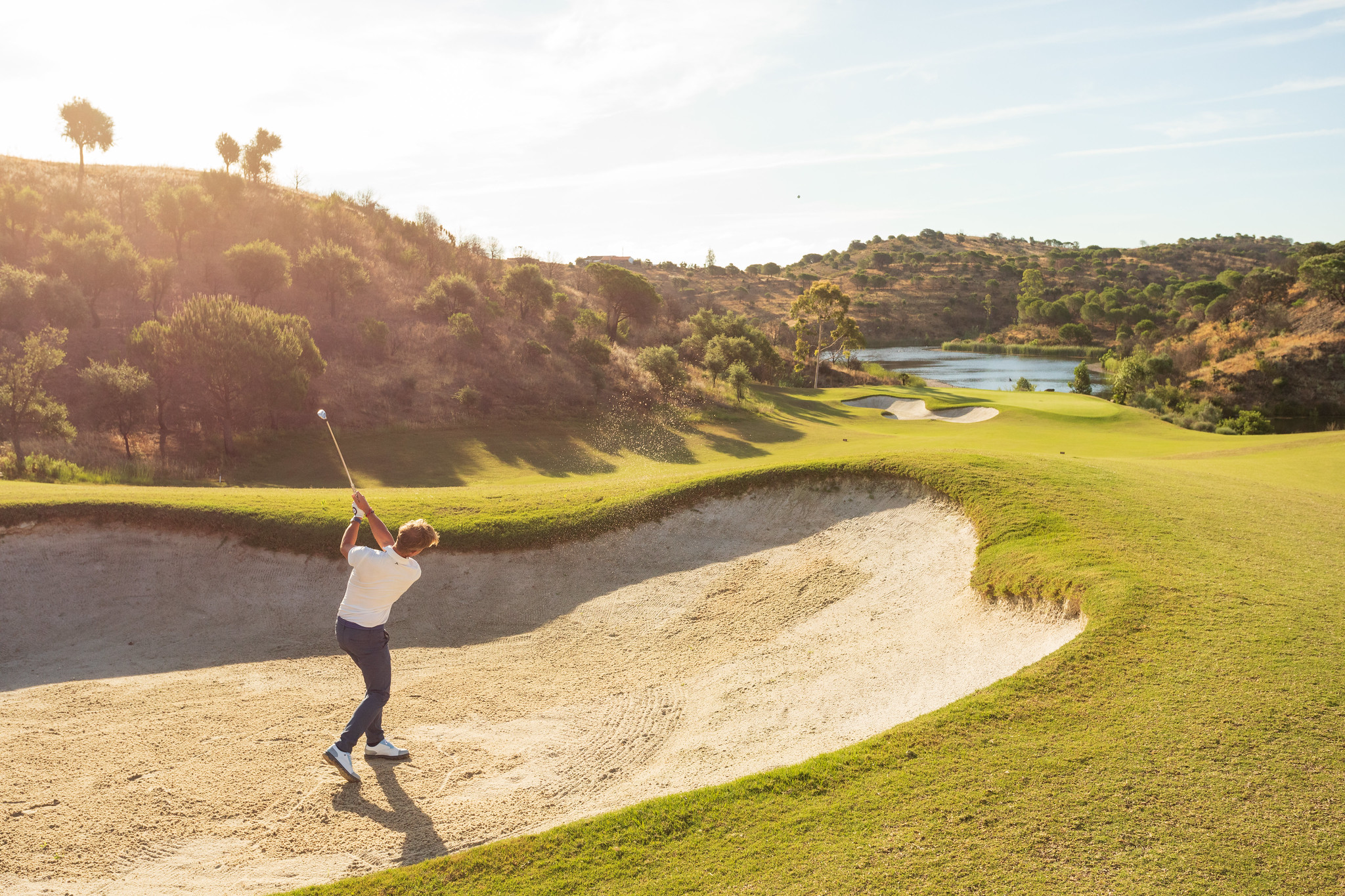 A golfer hits out of a bunker