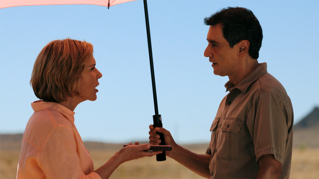 Carol and Manousos arguing under an umbrella in Pluribus episode 9