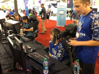 Two boys play a video game on desktop computer.