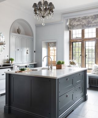 Black and white kitchen ideas with a large black island in an otherwise white, traditional scheme.