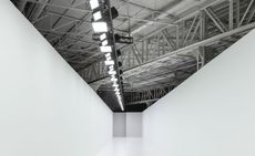 A white walled catwalk with lights above on metal girders