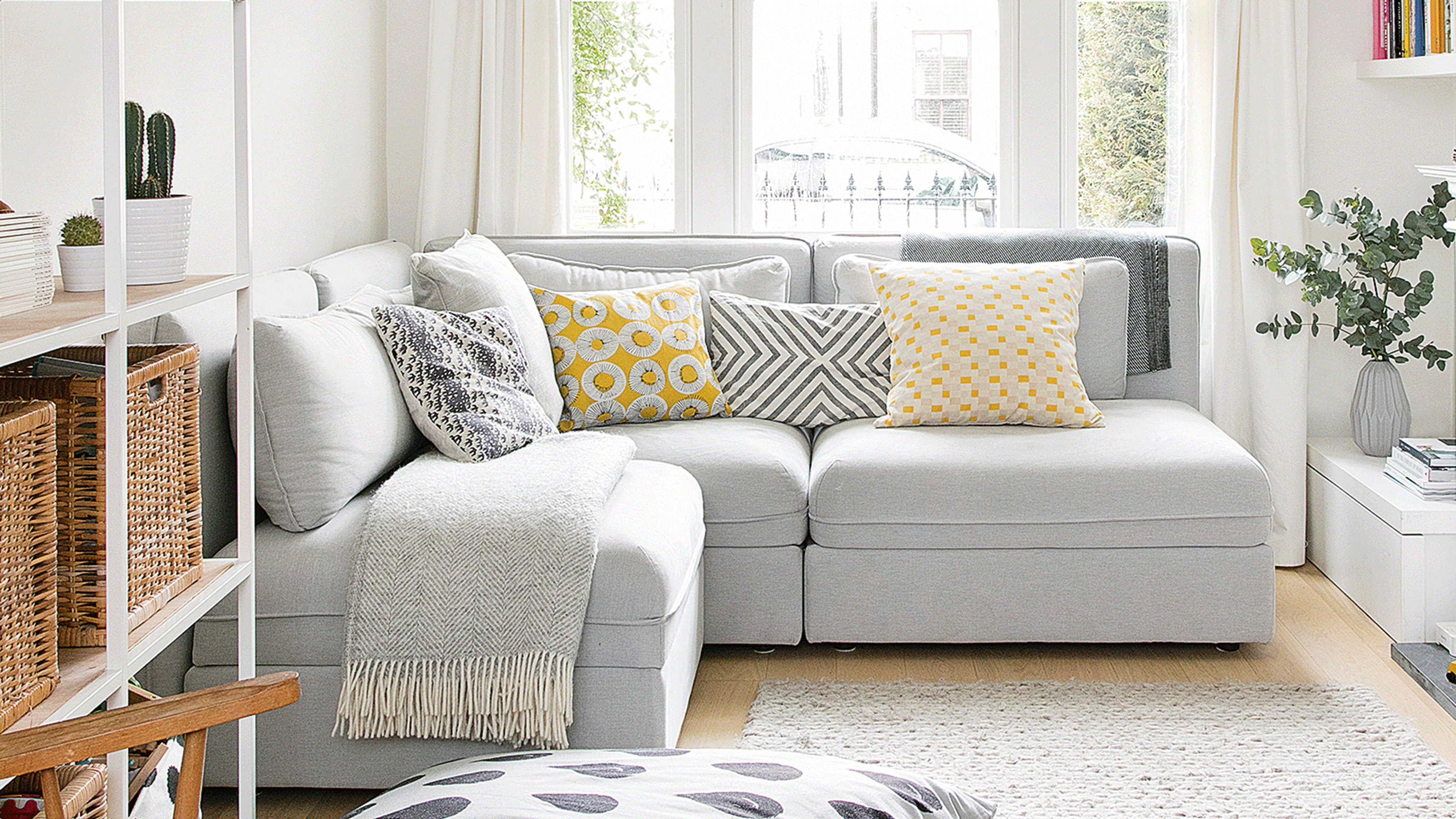 Grey modular corner sofa in small white living room 