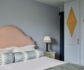 blue bedroom with built-in wardrobes and a red striped headboard