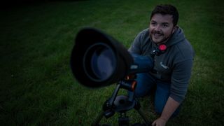 man using a telescope in a field