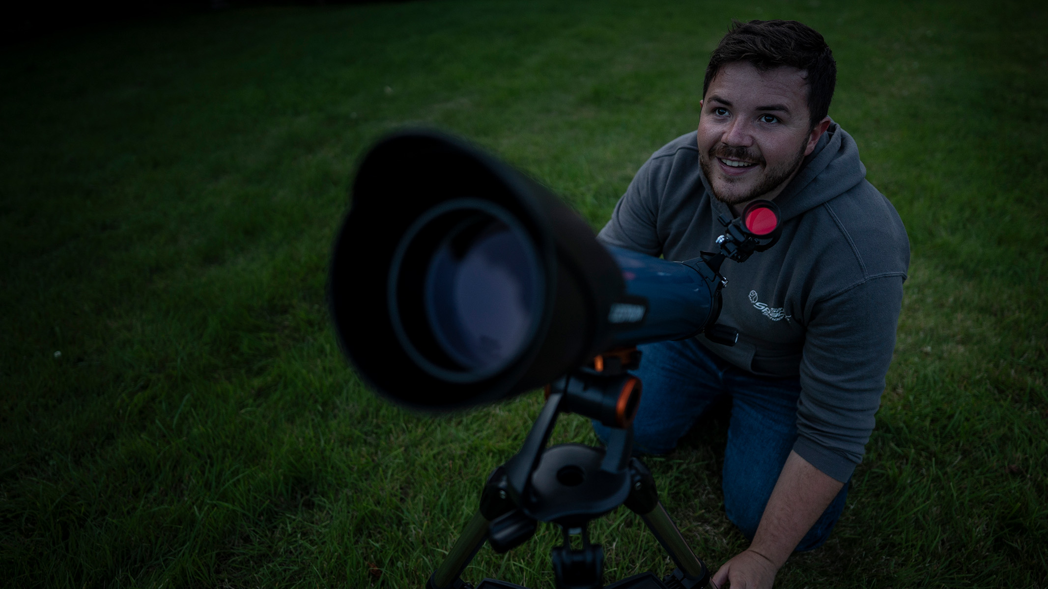 man using a telescope in a field