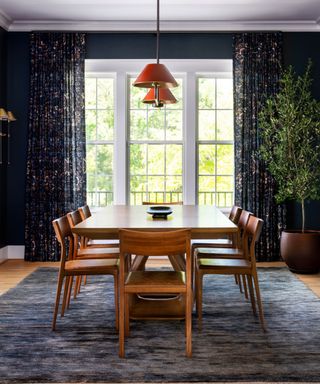 Dark blue dining room with wooden table and chairs