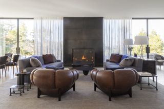 contemporary living space with fireplace and brown armchairs